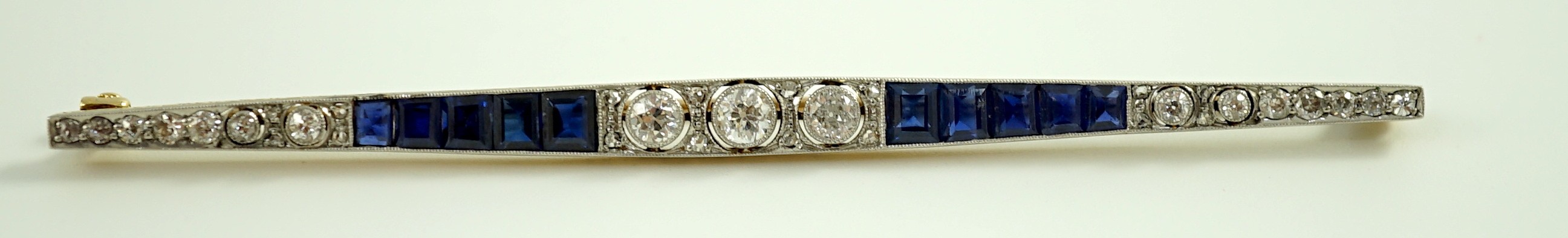 A 1920's/1930's 15ct gold and platinum, diamond and synthetic? sapphire set bar brooch